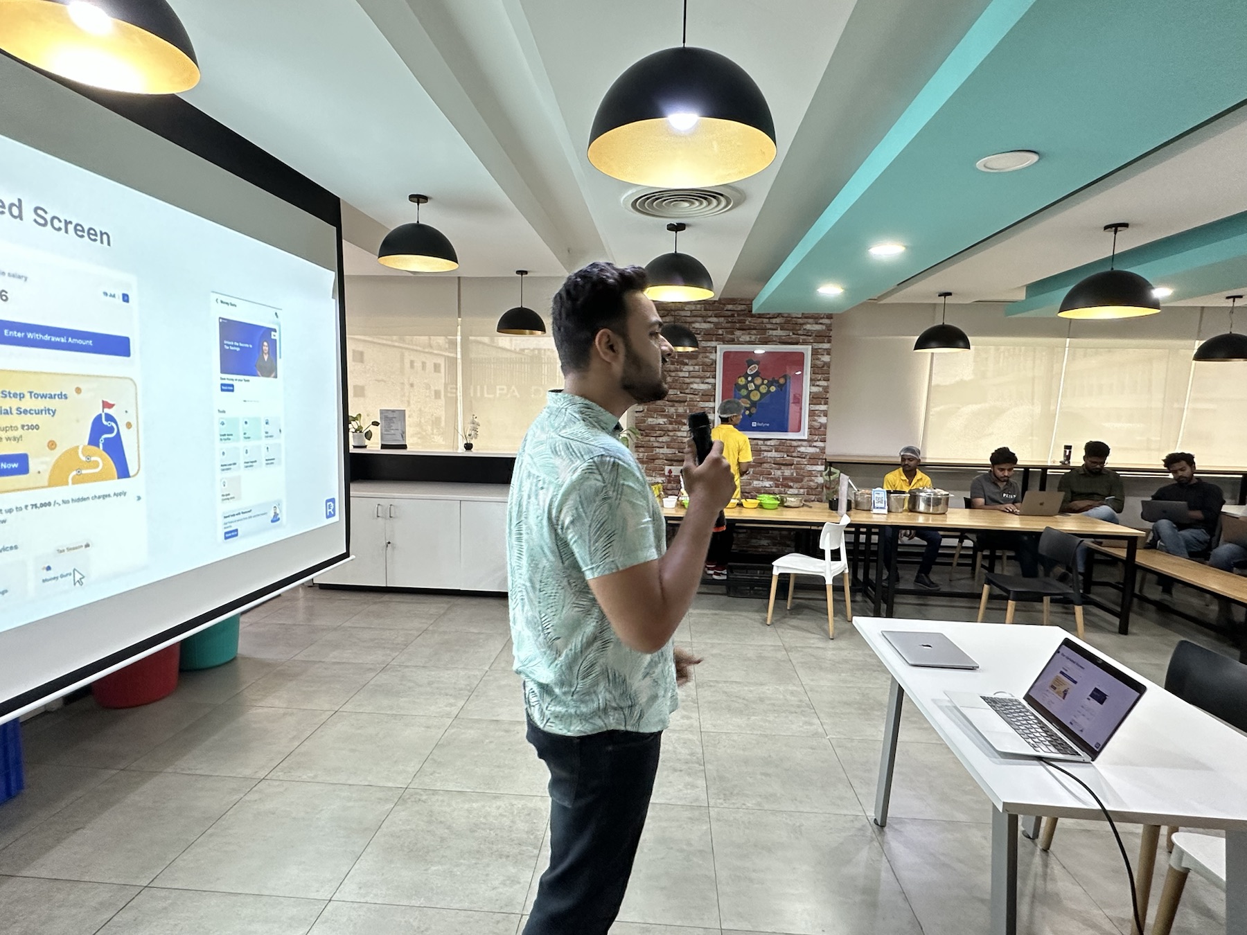 Manthan on stage presenting Refyne's financial-wellness impact.