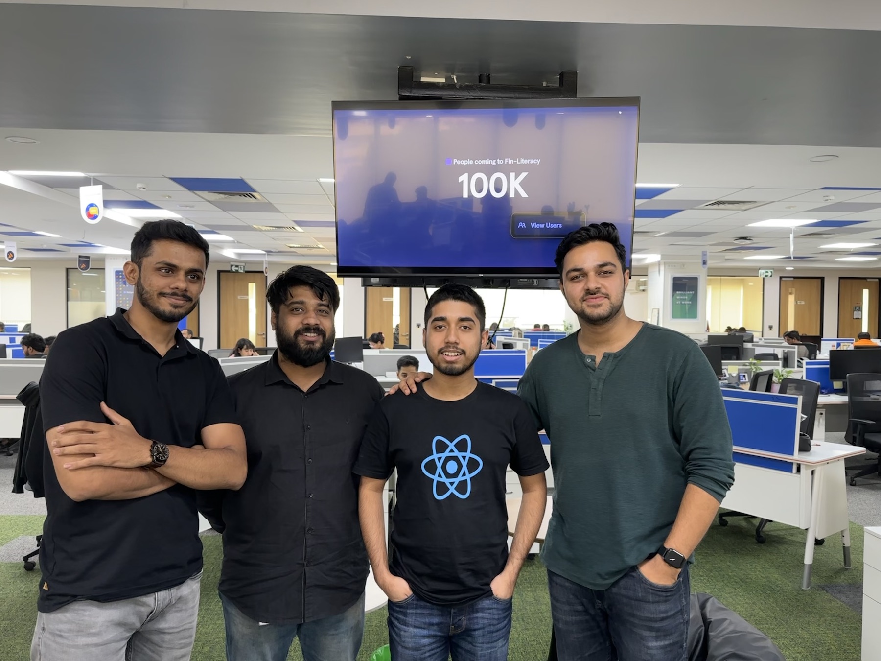 Refyne team in front of a screen showing 100K users on the financial-literacy feature.
